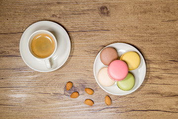 Fototapeta na wymiar rustic photograph of macarons and coffee with almonds on wooden table
