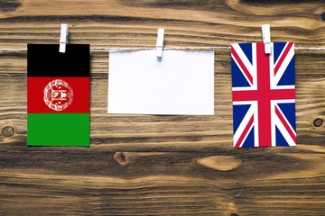Hanging flags of Afghanistan and United Kingdom attached to rope with clothes pins with copy space...