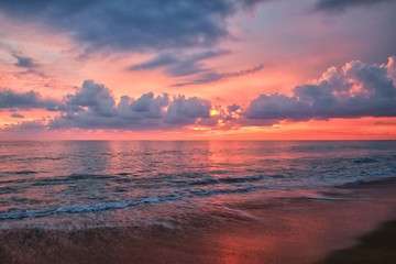 Fototapeta na wymiar Phuket beach sunset, colorful cloudy twilight sky reflecting on the sand gazing at the Indian Ocean, Thailand, Asia.