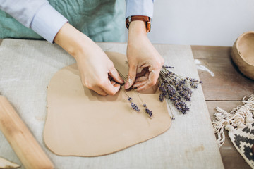 The potter's hands are shaped a cup from a clay. The process of creating pottery. The master ceramist works in his studio. Close-up, only hands. Crockery from clay own hands.