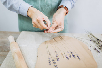 The potter's hands are shaped a cup from a clay. The process of creating pottery. The master ceramist works in his studio. Close-up, only hands. Crockery from clay own hands.