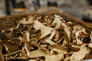 Homemade Dried Porcinis on a wooden table as a detailed close-up shot; Basket with mushrooms on the market.