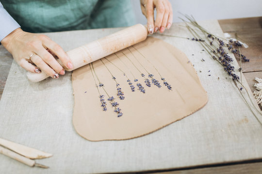 The potter's hands are shaped a cup from a clay. The process of creating pottery. The master ceramist works in his studio. Close-up, only hands. Crockery from clay own hands.