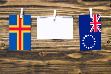 Hanging flags of Aland Islands and Cook Islands attached to rope with clothes pins with copy space...