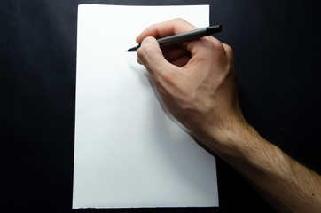 The male left and right hand holds a pen over a white sheet of paper on a black background. Items per sheet, Sports and Fitnec