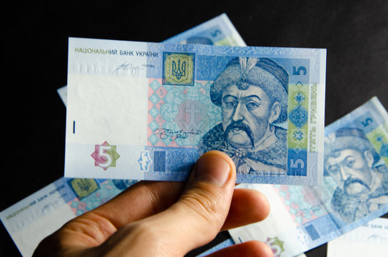 The Ukrainian hryvnia denominated five, ten, twenty hryvnias scattered and neatly linked. Hryvnia in male hands and in a wallet. Theft of Ukrainian hryvnia money