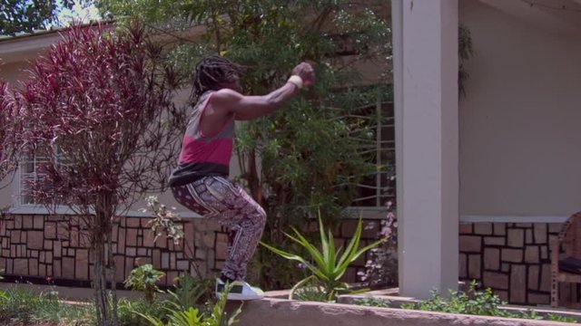 Super slow motion young man doing a backflip at home while practicing parkour wide shot training skills