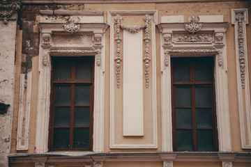 Fototapeta na wymiar two very old windows on the yellow wall with nobody.