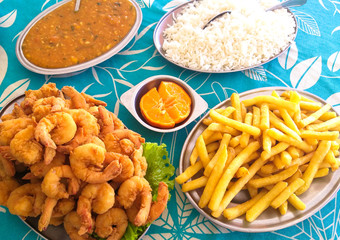 Mesa com camarão a milanesa, batata frita, arroz e pirão de peixe