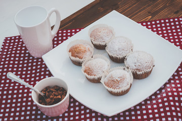 sweet muffins on a plate with a cup of chocolate