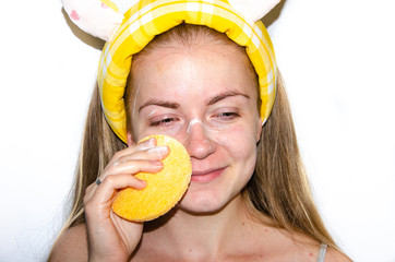 A European girl is applying Korean cosmetics to her face mask. Cleanses pores, grease, acne,...