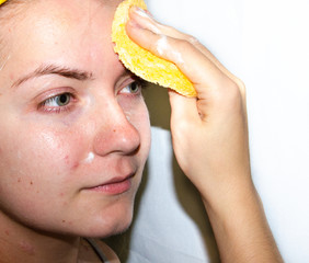 A European girl is applying Korean cosmetics to her face mask. Cleanses pores, grease, acne,...