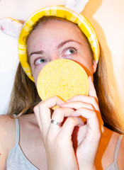 A European girl is applying Korean cosmetics to her face mask. Cleanses pores, grease, acne,...