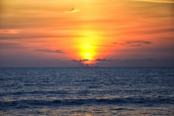 Phuket beach sunset, colorful cloudy twilight sky reflecting on the sand gazing at the Indian Ocean, Thailand, Asia.