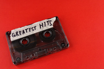 vintage old film music cassette on a red background with the inscription greatest hits, background...
