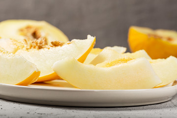 Sweet yellow fresh melon on white concrete table