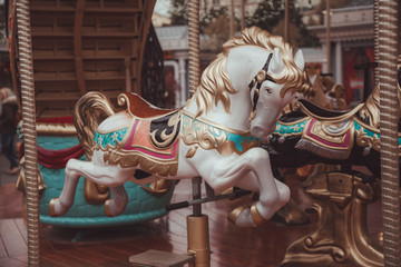 Old carousel with horses in a holiday autumn evening park with nobody