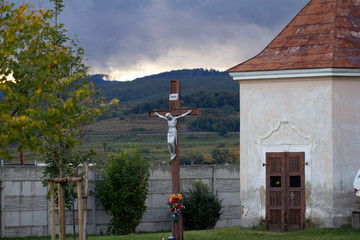 crucifix with jesus christ in front of small chapel