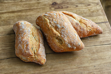 Four crispy buns on a wooden table