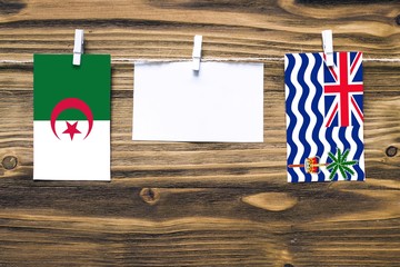 Hanging flags of Algeria and British Indian Ocean Territory attached to rope with clothes pins with...
