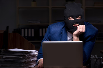 Male employee stealing information in the office night time
