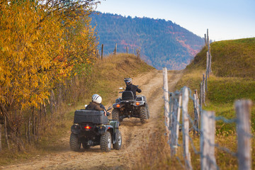 All terrain vehicles, quad bikes, atv, riding through beautiful rural scenery in autumn