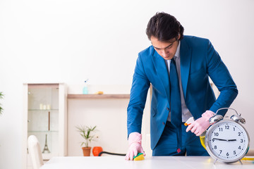 Young businessman cleaning the house