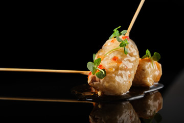 Food in batter on a black background with flowers