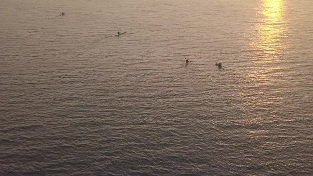 Long, narrow and fast racing sea kayaks. Early morning on a background of amazing sunrise.