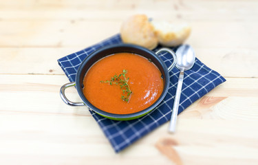 schmackhafte Tomatensuppe im ländlichen Stil angerichtet mit unscharfen Hintergrund.