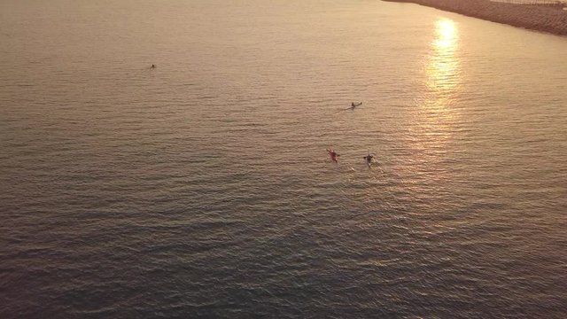 Long, narrow and fast racing sea kayaks. Early morning on a background of amazing sunrise.