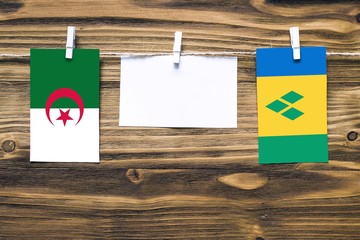 Hanging flags of Algeria and Saint Vincent And The Grenadines attached to rope with clothes pins...
