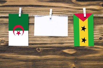Hanging flags of Algeria and Sao Tome And Principe attached to rope with clothes pins with copy...