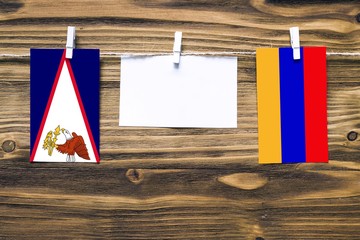 Hanging flags of American Samoa and Armenia attached to rope with clothes pins with copy space on...