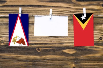 Hanging flags of American Samoa and East Timor attached to rope with clothes pins with copy space...