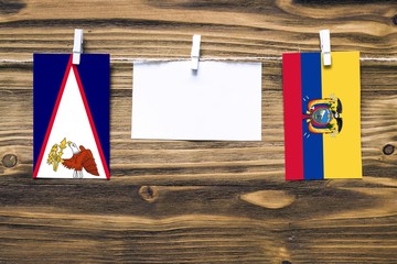 Hanging flags of American Samoa and Ecuador attached to rope with clothes pins with copy space on...