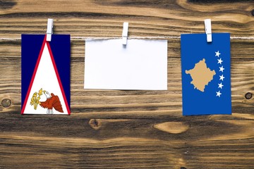 Hanging flags of American Samoa and Kosovo attached to rope with clothes pins with copy space on...