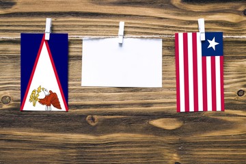 Hanging flags of American Samoa and Liberia attached to rope with clothes pins with copy space on...