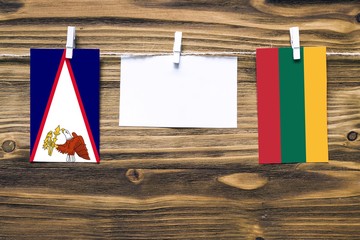 Hanging flags of American Samoa and Lithuania attached to rope with clothes pins with copy space on...