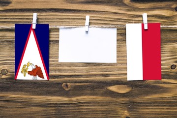 Hanging flags of American Samoa and Monaco attached to rope with clothes pins with copy space on...