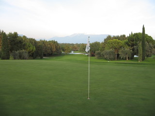 Obraz premium Golfloch mit Fahne auf dem Green - Golfplatz