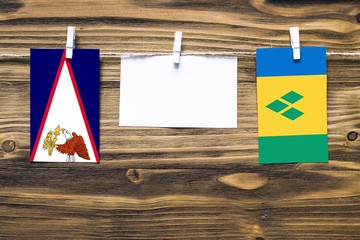 Hanging flags of American Samoa and Saint Vincent And The Grenadines attached to rope with clothes...