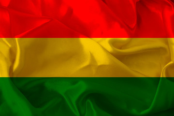 beautiful photo of a colored national flag of the modern state of Bolivia on a textured fabric, concept of tourism, emigration, economy and politics, close up