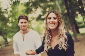 Obraz premium Couple of smiling lovers walk in a park.