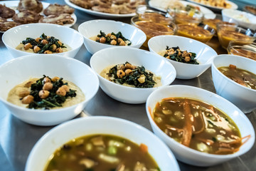 Group of plates with soups of various types in hot bowls.
