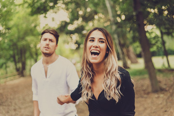 Fototapeta premium Laughing woman cheats on her boyfriend with lies to get rid of him.