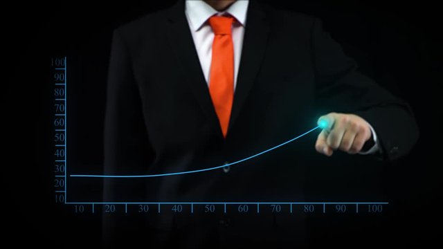 Businessman uses holographic interface, drawing an ascending financial chart. Business success.