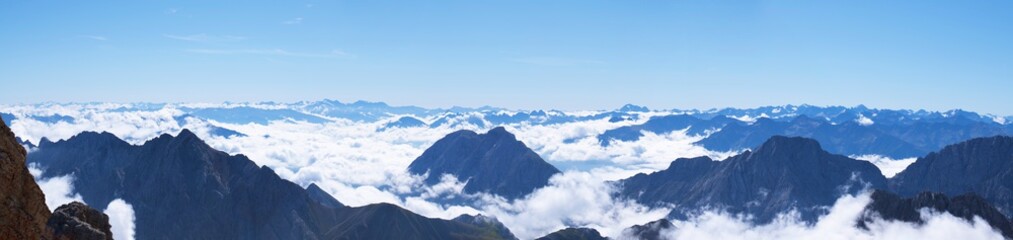 Fototapeta na wymiar Wide angle View of Mountain peaks raising out of the cloud line