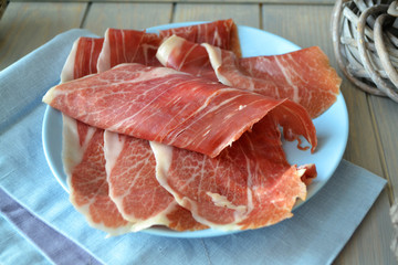 Portion of Sliced Ham on blue plate, rustic style