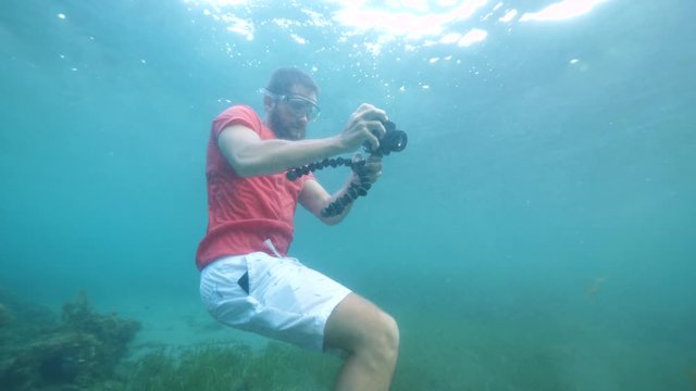 A young man making funny underwater photos and selfies.